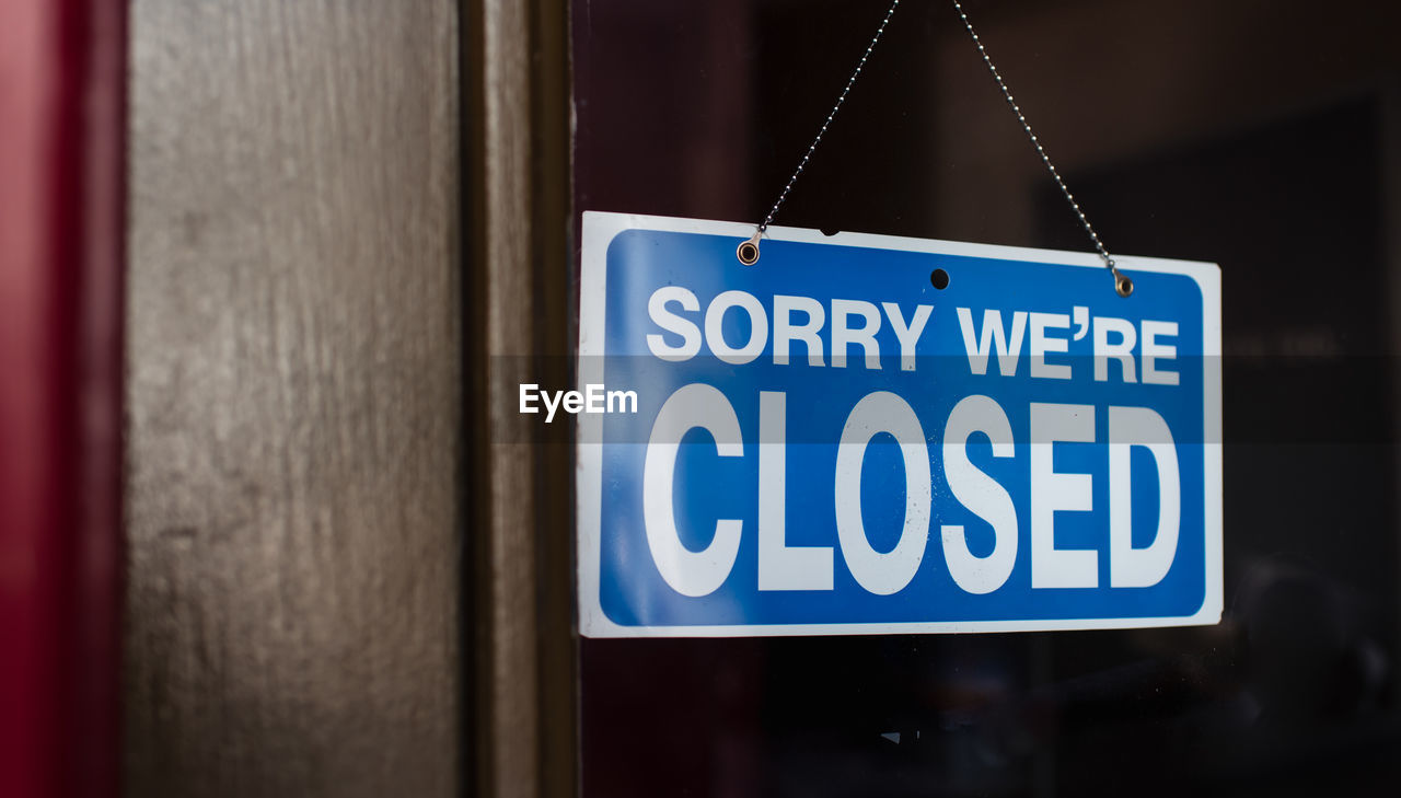 Close up of a closed sign hanging in the window of a store.