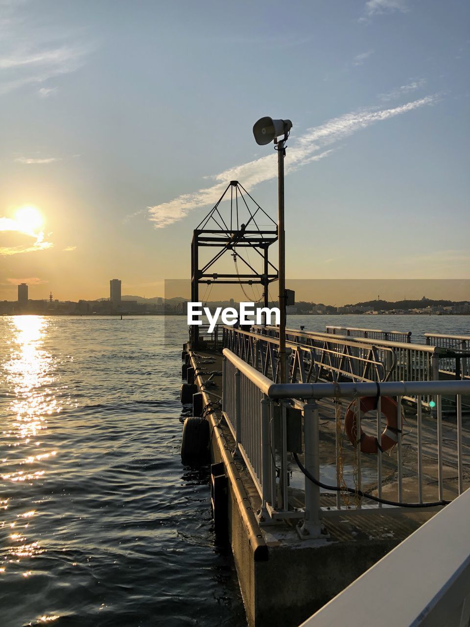 Pier over sea against sky during sunset