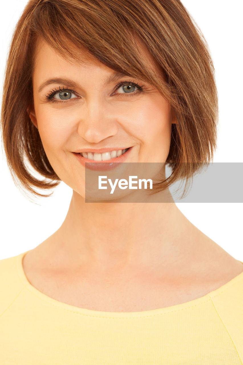 Portrait of smiling mid adult woman against white background