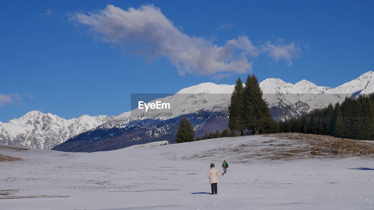 snow, mountain, cold temperature, winter, sky, mountain range, scenics - nature, environment, landscape, beauty in nature, leisure activity, one person, nature, snowcapped mountain, travel, adventure, vacation, sports, cloud, travel destinations, skiing, holiday, full length, land, trip, winter sports, day, activity, blue, hiking, ridge, adult, tourism, non-urban scene, tranquil scene, lifestyles, tranquility, piste, outdoors, tree, men, walking, ski mountaineering, white