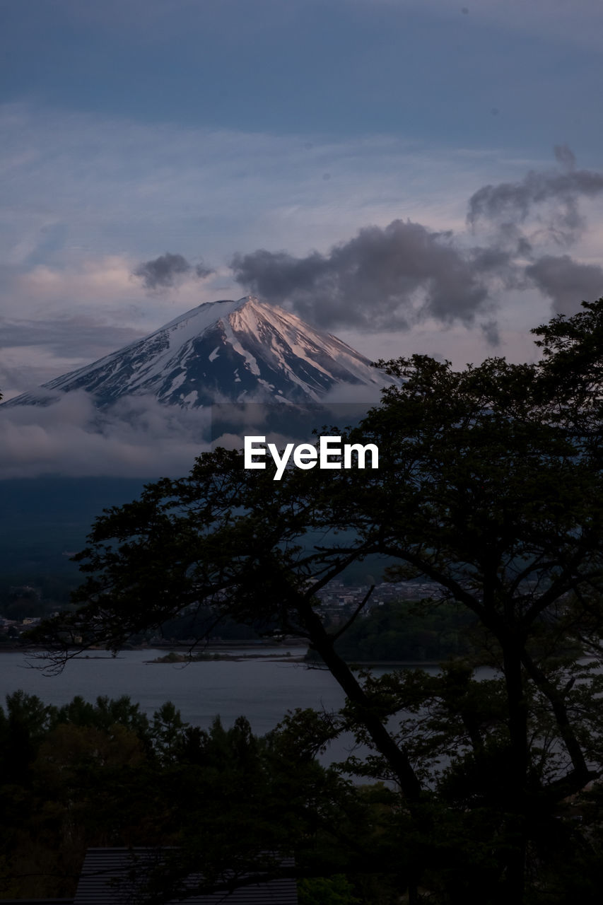 VIEW OF VOLCANIC MOUNTAIN AGAINST CLOUDY SKY