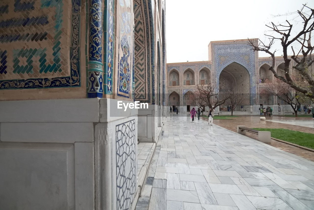 architecture, built structure, building exterior, travel destinations, history, the past, group of people, tourism, travel, city, place of worship, religion, building, arch, day, nature, adult, outdoors, women, footpath, tourist, lifestyles, sky, entrance, belief, men, walking, wall