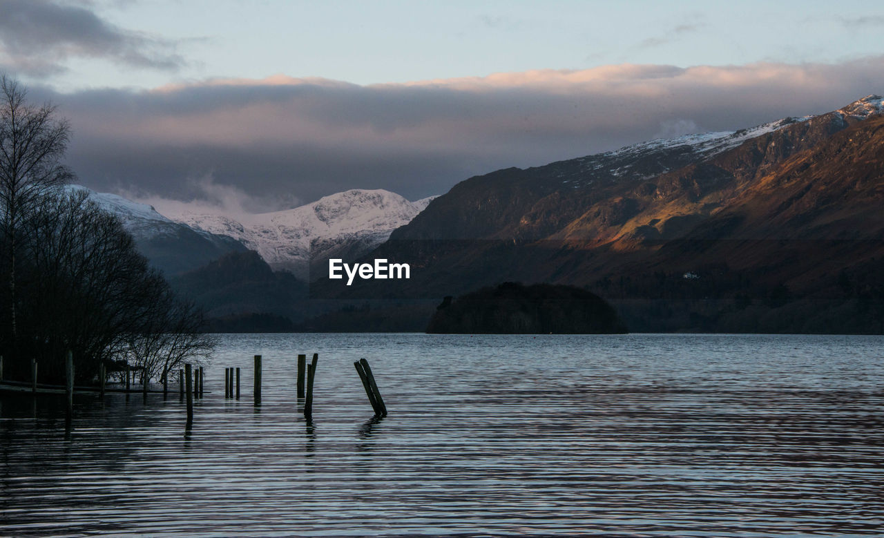 Scenic view of river and mountains against sky