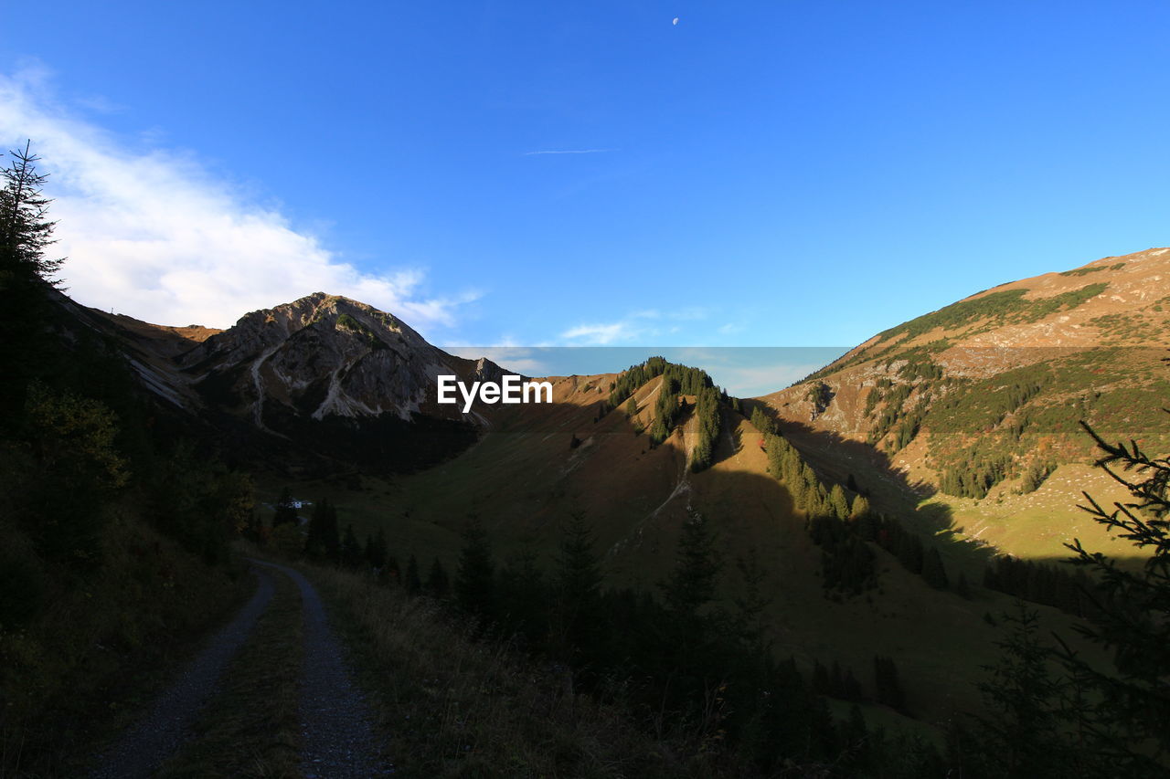 ROAD AMIDST MOUNTAINS AGAINST SKY