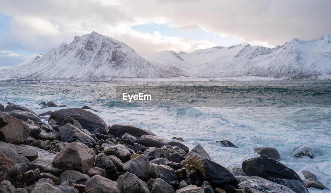 SCENIC VIEW OF SEA BY MOUNTAINS AGAINST SKY