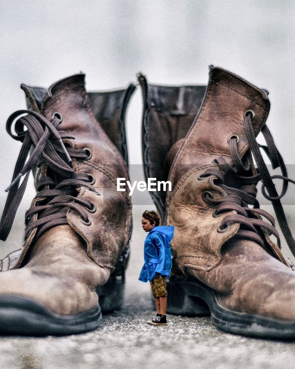 Digitally generated image of boy standing by shoes