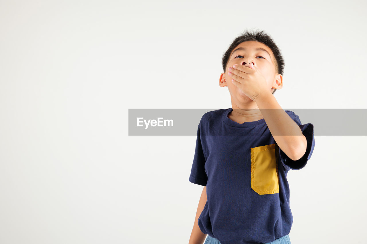 portrait of smiling young woman standing against white background