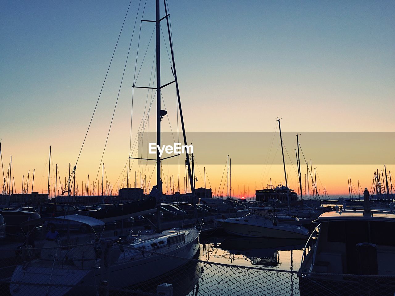 SAILBOATS MOORED AT SUNSET