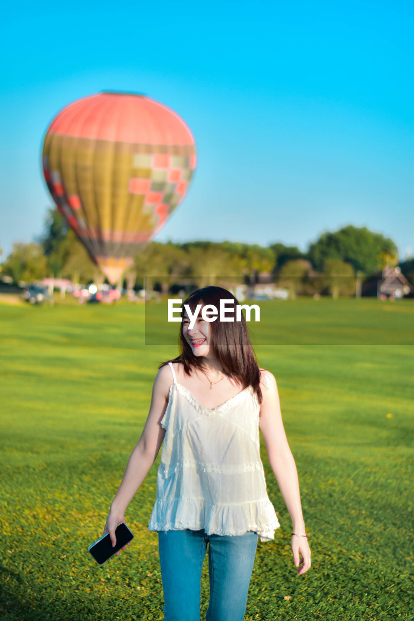 Rear view of woman with hot air balloons against sky