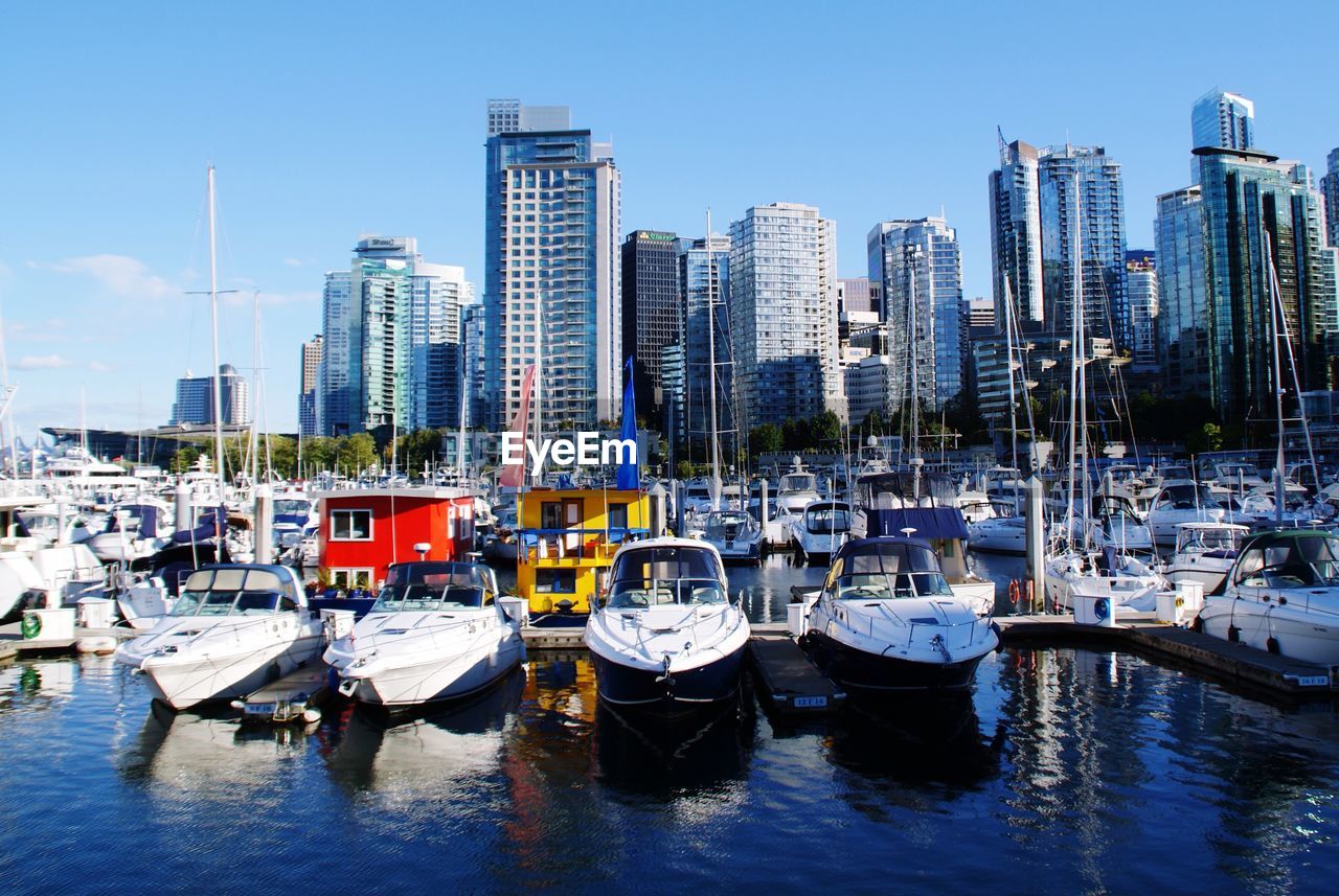 Boats moored at harbor in city