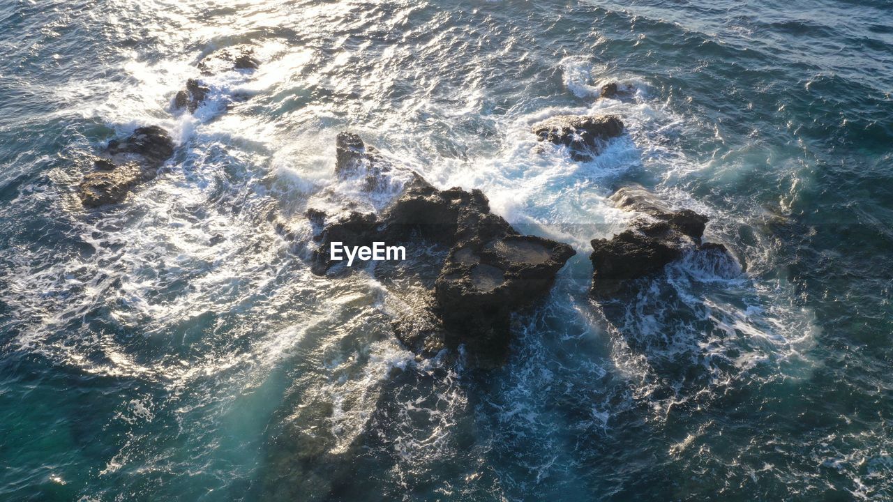 HIGH ANGLE VIEW OF WAVES ON SHORE