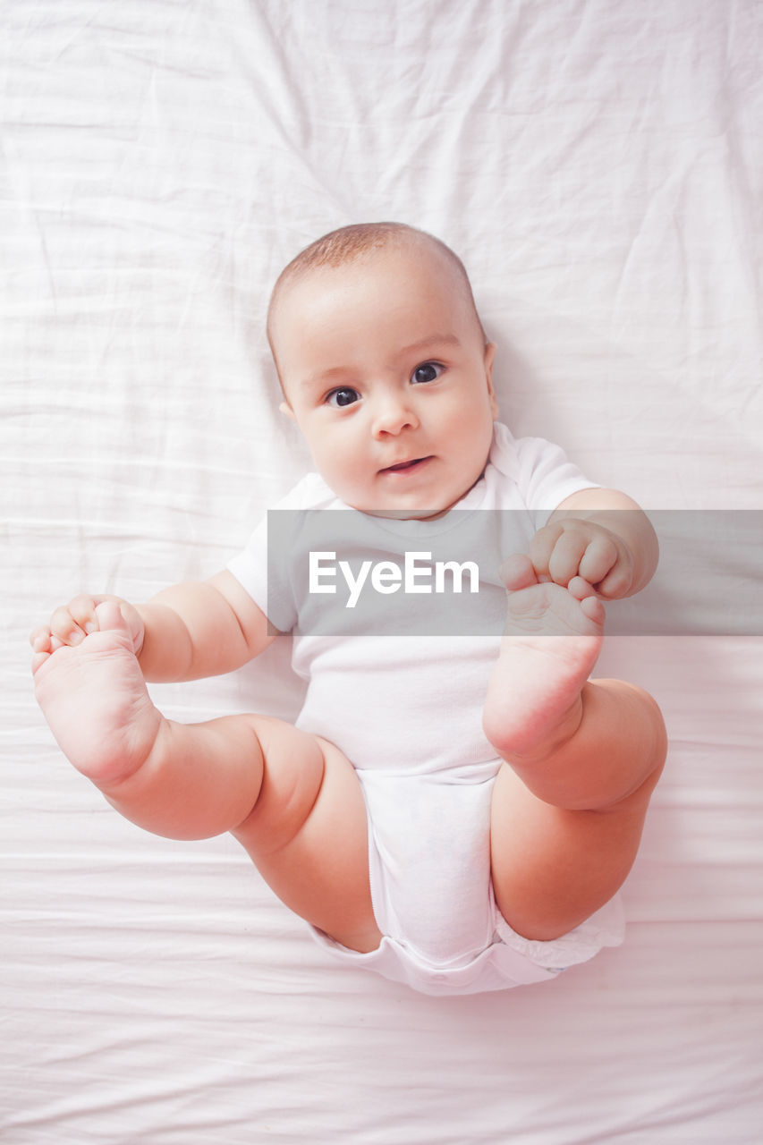 High angle view of cute baby boy on bed