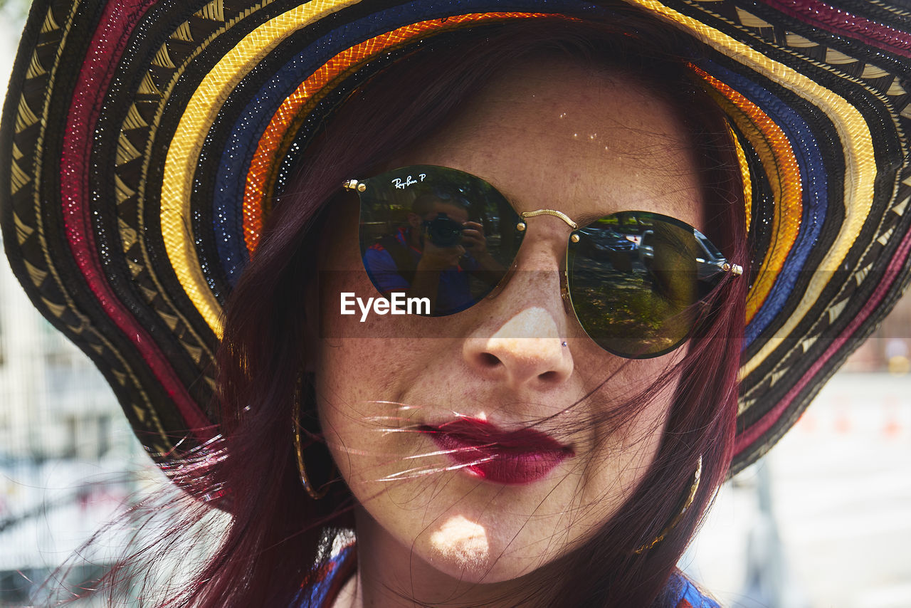 Portrait of young woman wearing sunglasses and hat