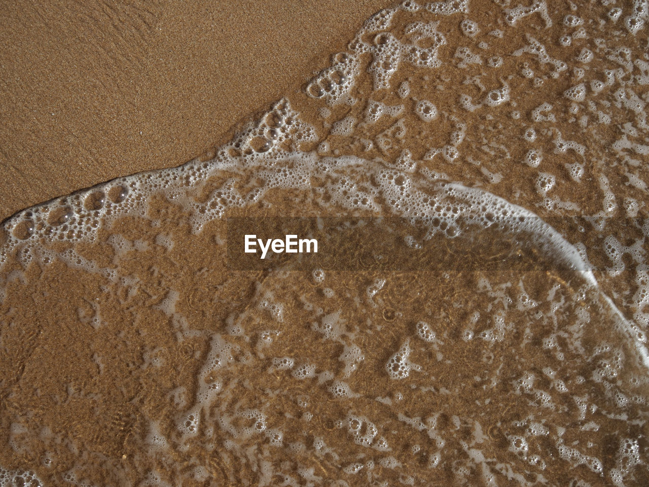 CLOSE-UP OF WET SAND