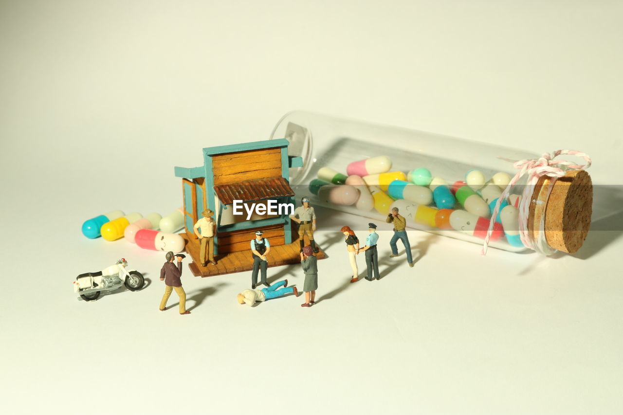 High angle view of figurines and pills on table