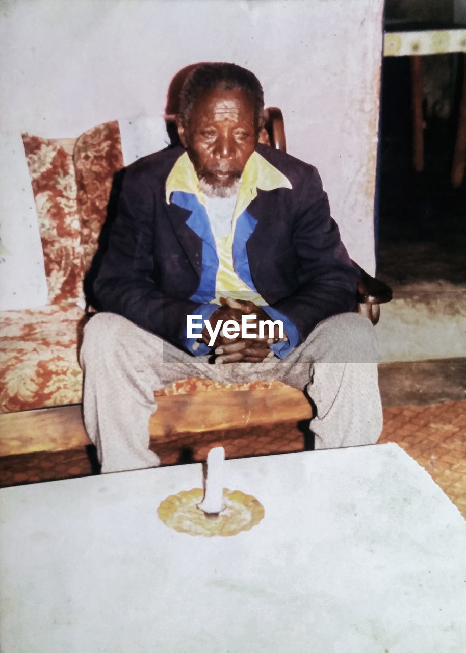 PORTRAIT OF A SMILING YOUNG MAN SITTING WITH FOOD