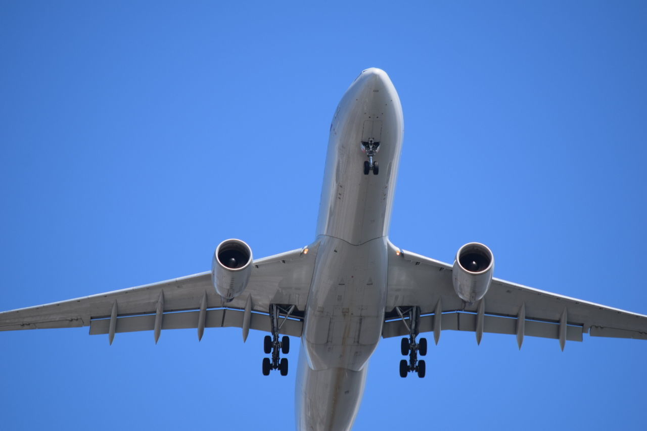 Low angle view of airplane against blue sky