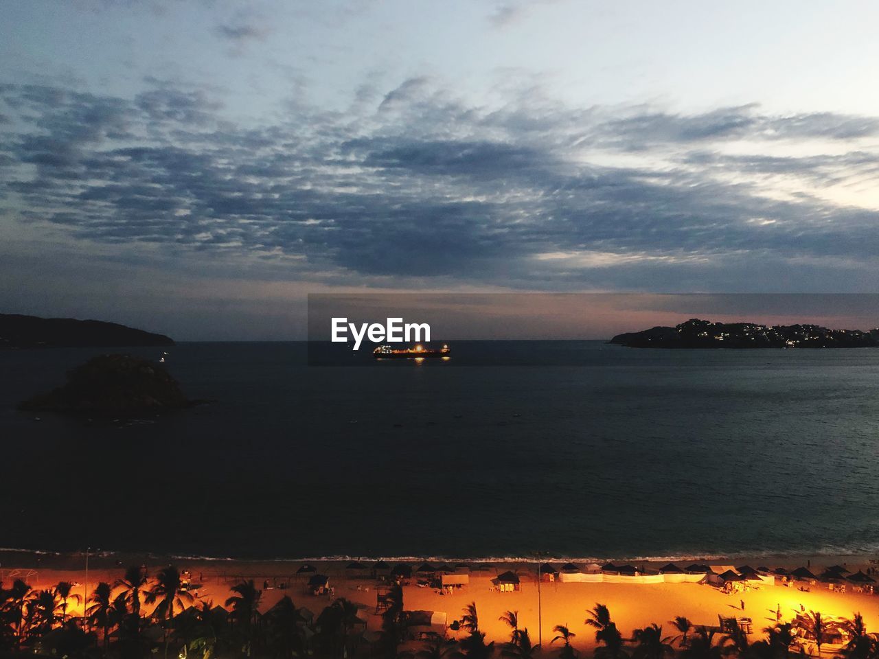 SCENIC VIEW OF BEACH AGAINST CLOUDY SKY