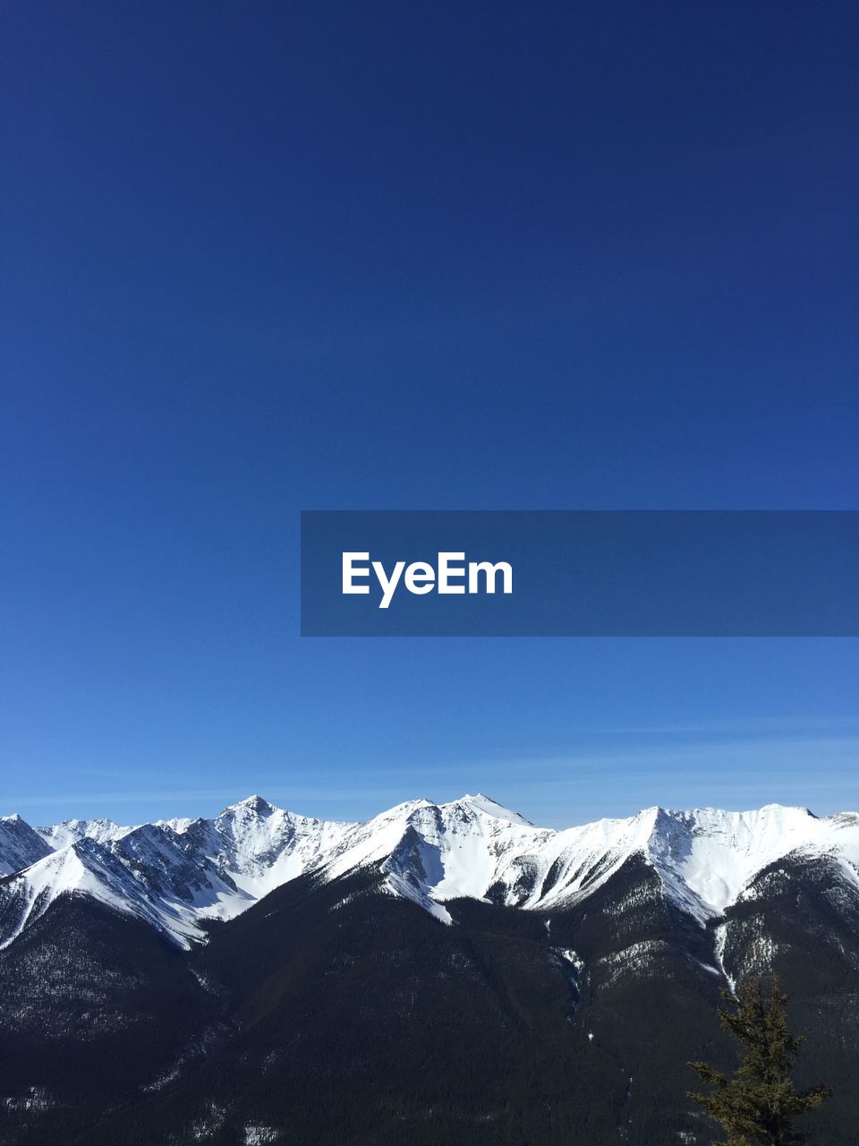 Scenic view of snowcapped mountains against blue sky