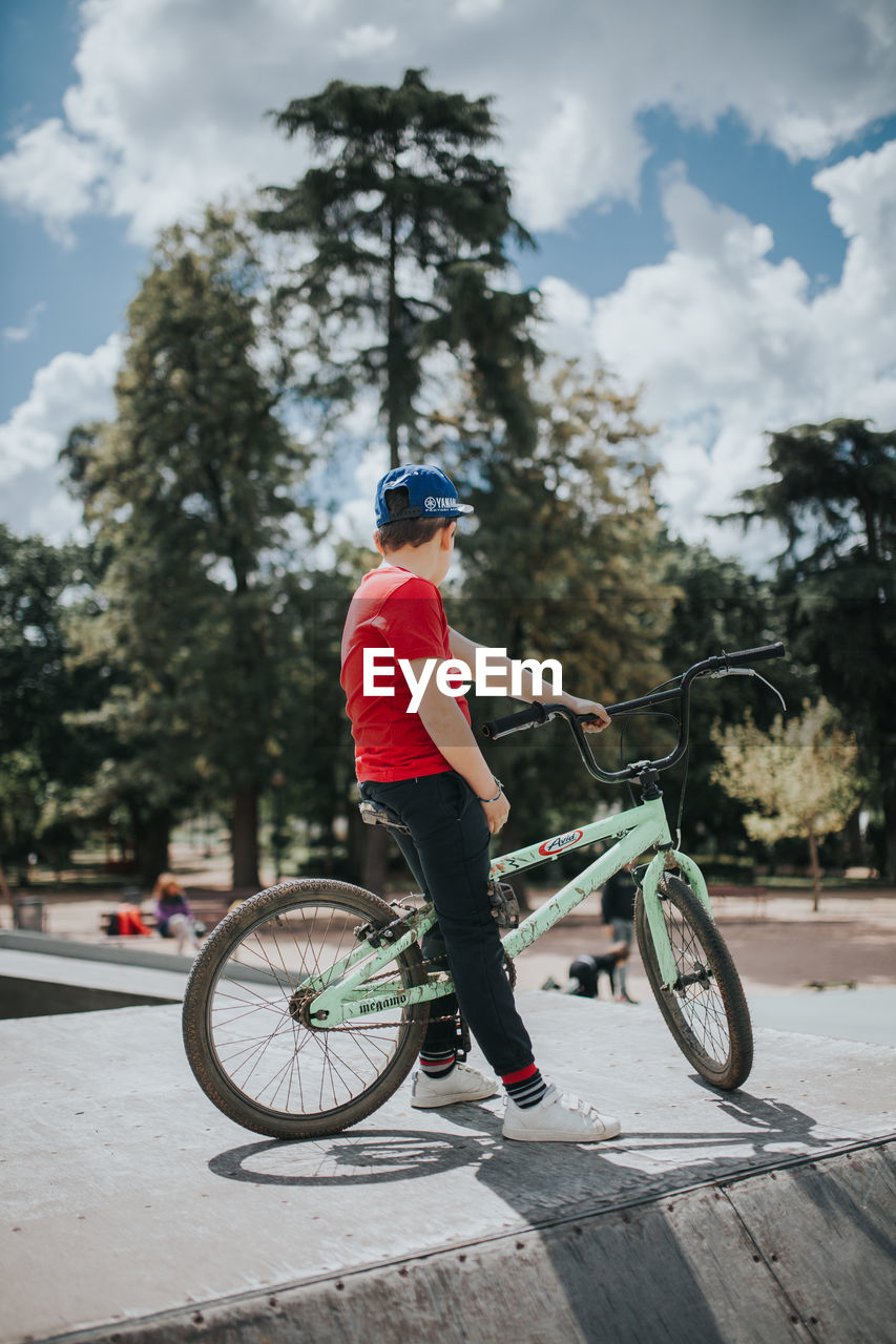 FULL LENGTH OF MAN RIDING BICYCLE ON TREE