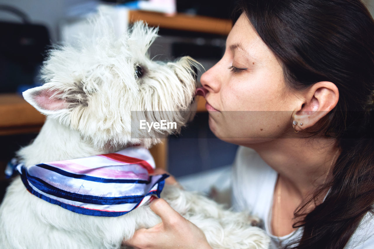Close-up of dog licking woman face
