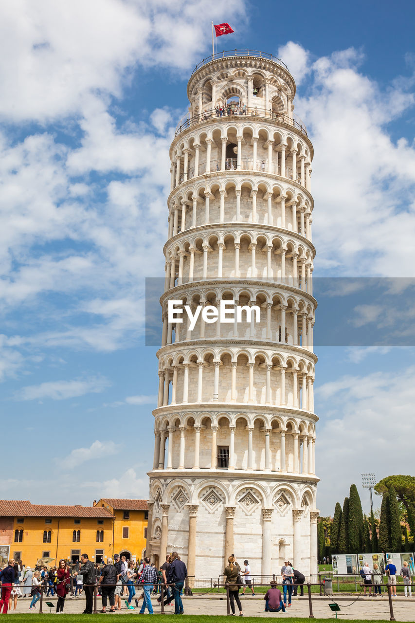 Tourists at the leaning tower of pisa in a beautiful early spring day