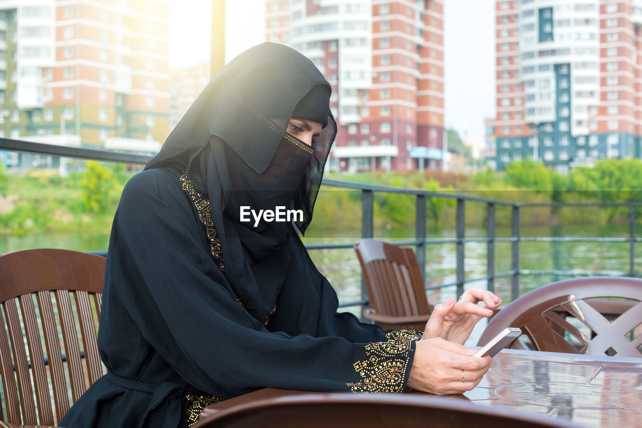 Muslim woman resting cafe waiting for her order.