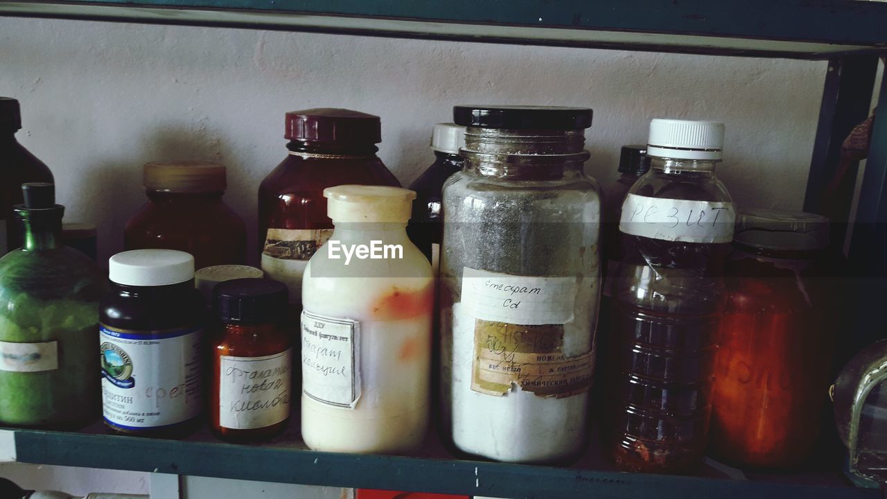 CLOSE-UP OF WINE BOTTLES IN SHELF