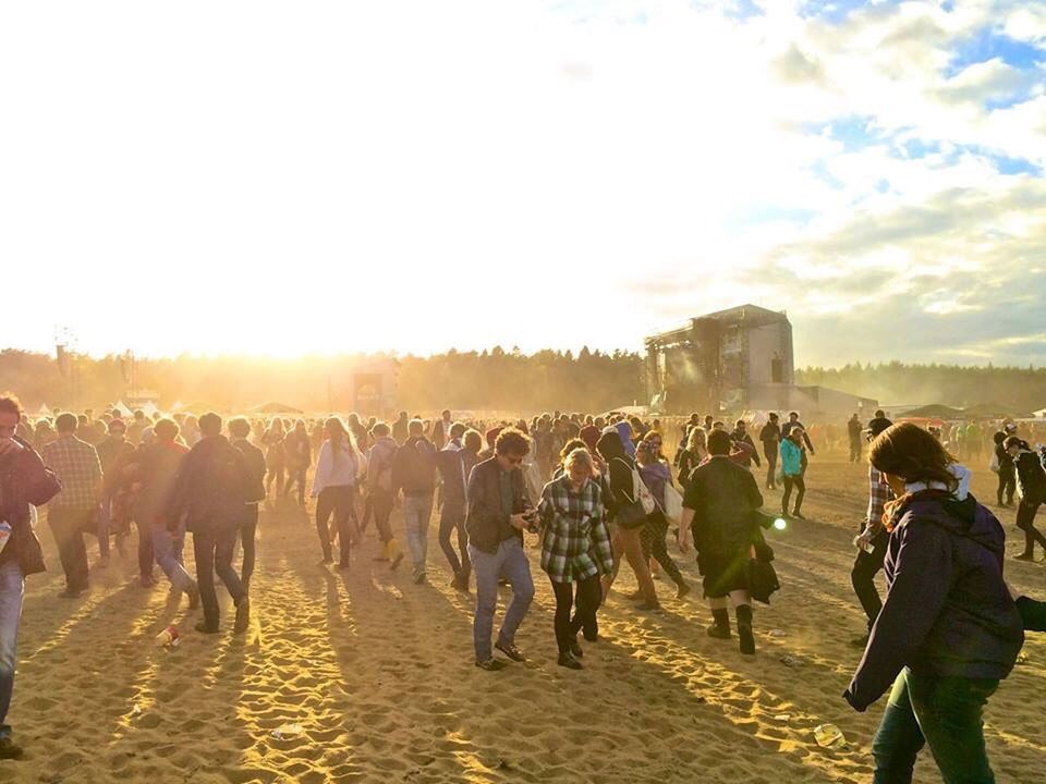 People walking on sandy beach during sunset