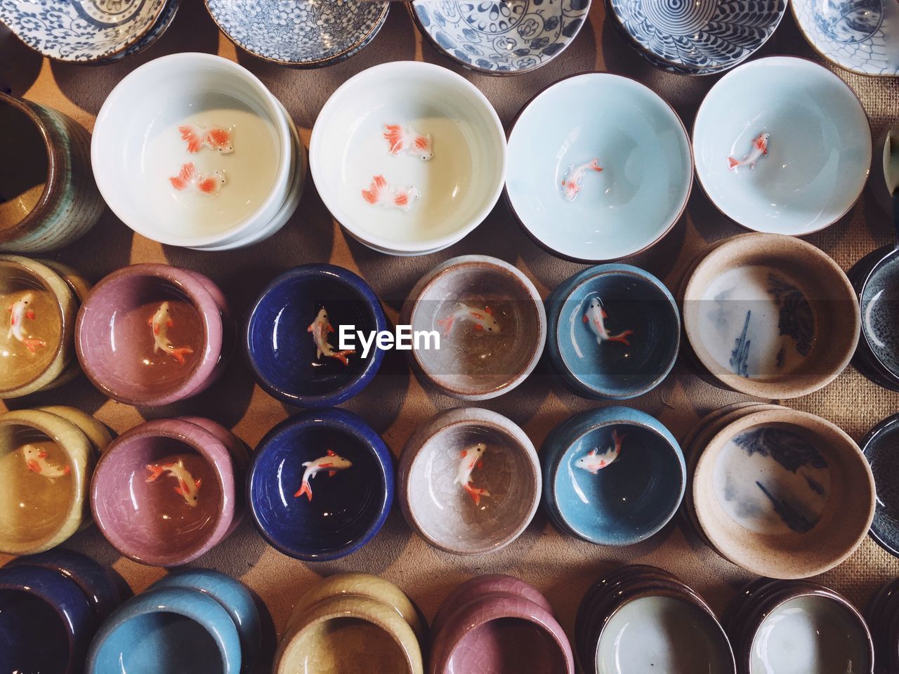 Directly above shot of artificial fish in colorful bowls