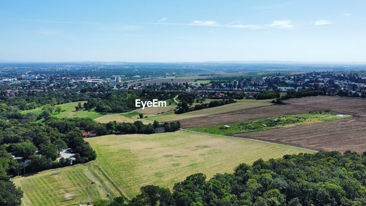 HIGH ANGLE VIEW OF FIELD AGAINST SKY IN CITY