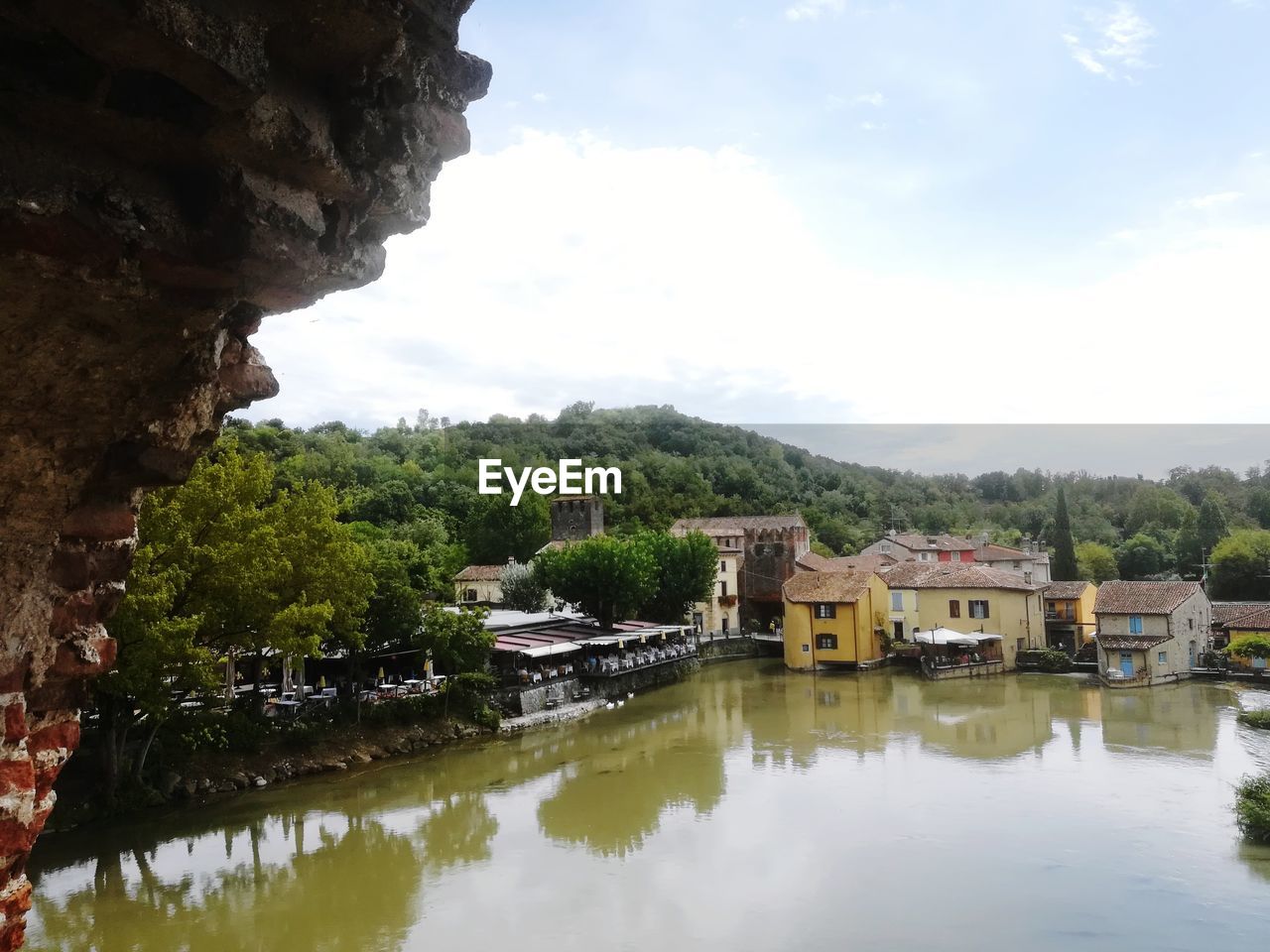 LAKE BY BUILDINGS AGAINST SKY