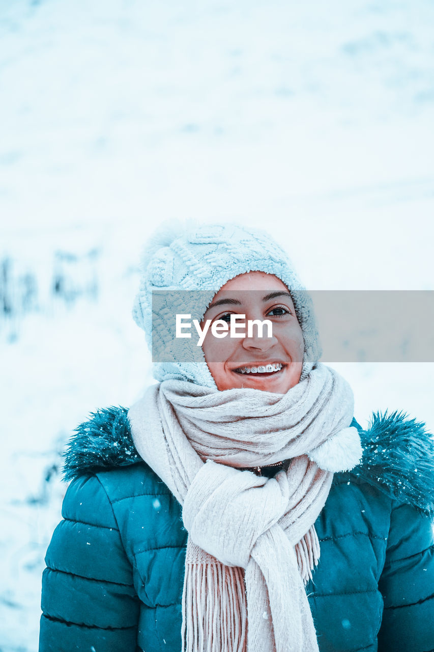 Close-up of smiling woman looking away during winter