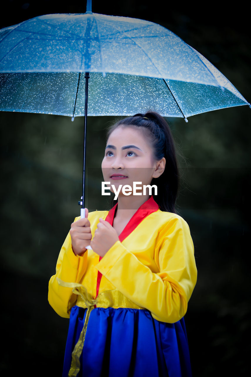 Portrait of young woman holding umbrella