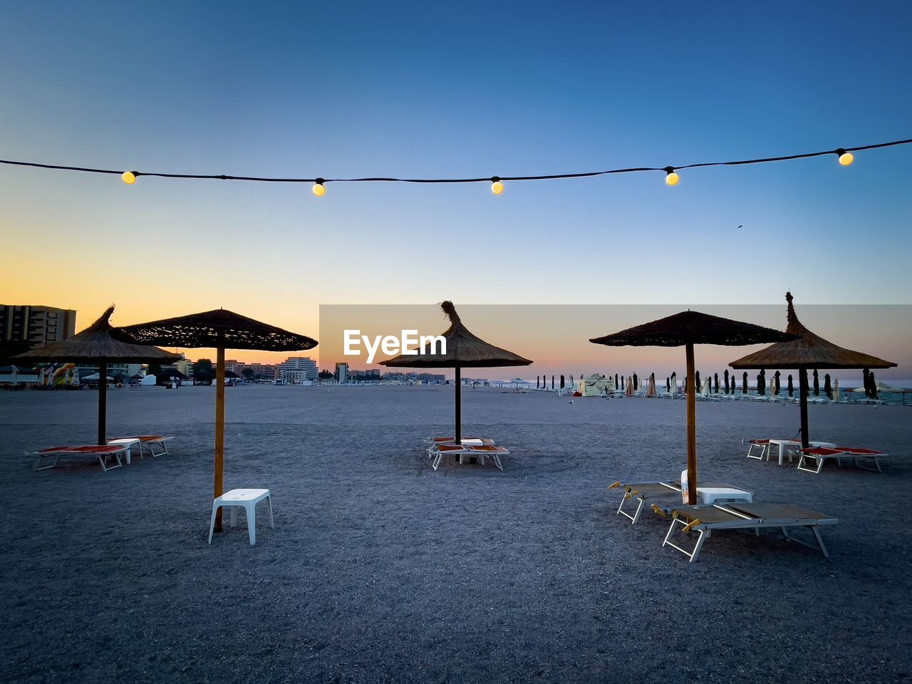 Sunbeds and umbrellas on the empty beach in the evening