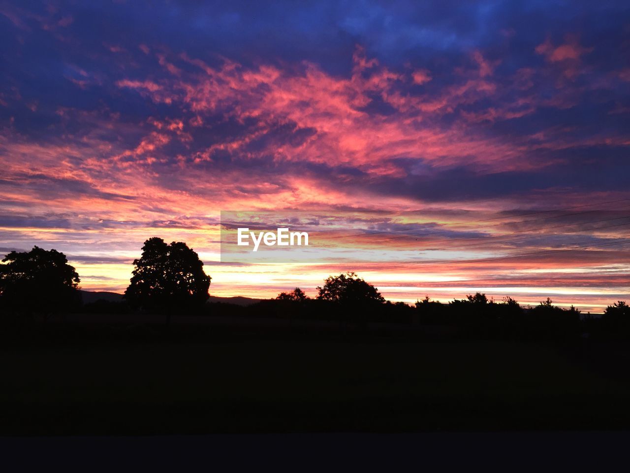 SCENIC VIEW OF SILHOUETTE TREES AGAINST SKY AT SUNSET