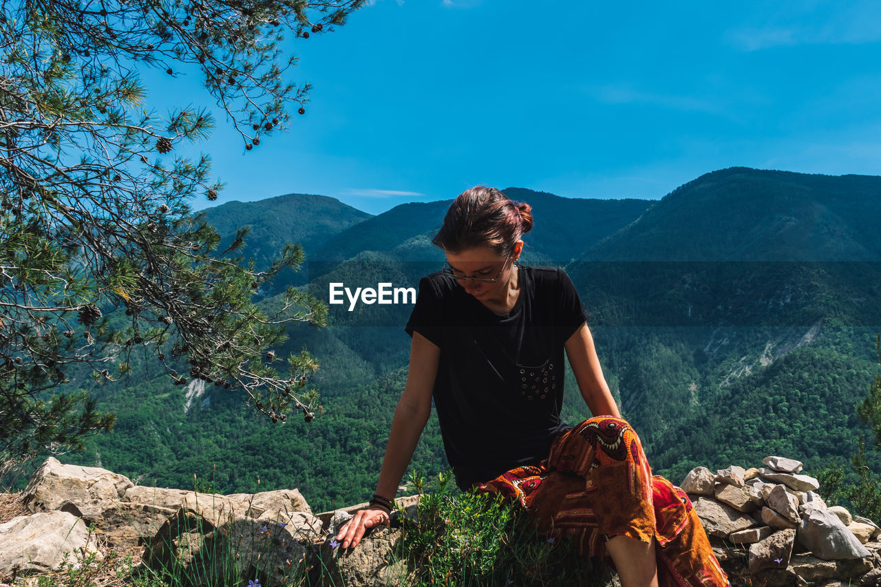 YOUNG WOMAN AGAINST MOUNTAINS