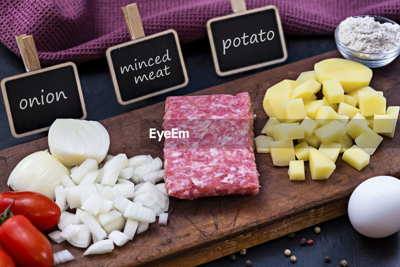 HIGH ANGLE VIEW OF CHOPPED VEGETABLES AND CUTTING BOARD