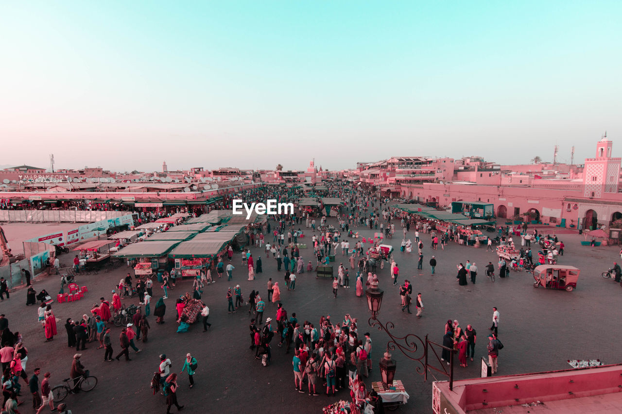 HIGH ANGLE VIEW OF CROWD IN CITY AGAINST SKY