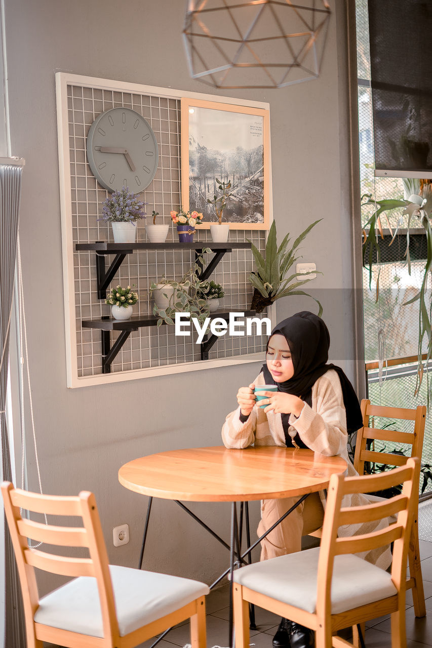 WOMAN SITTING IN RESTAURANT