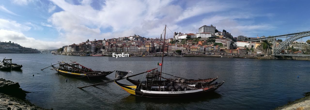 PANORAMIC VIEW OF RIVER AMIDST BUILDINGS AGAINST SKY