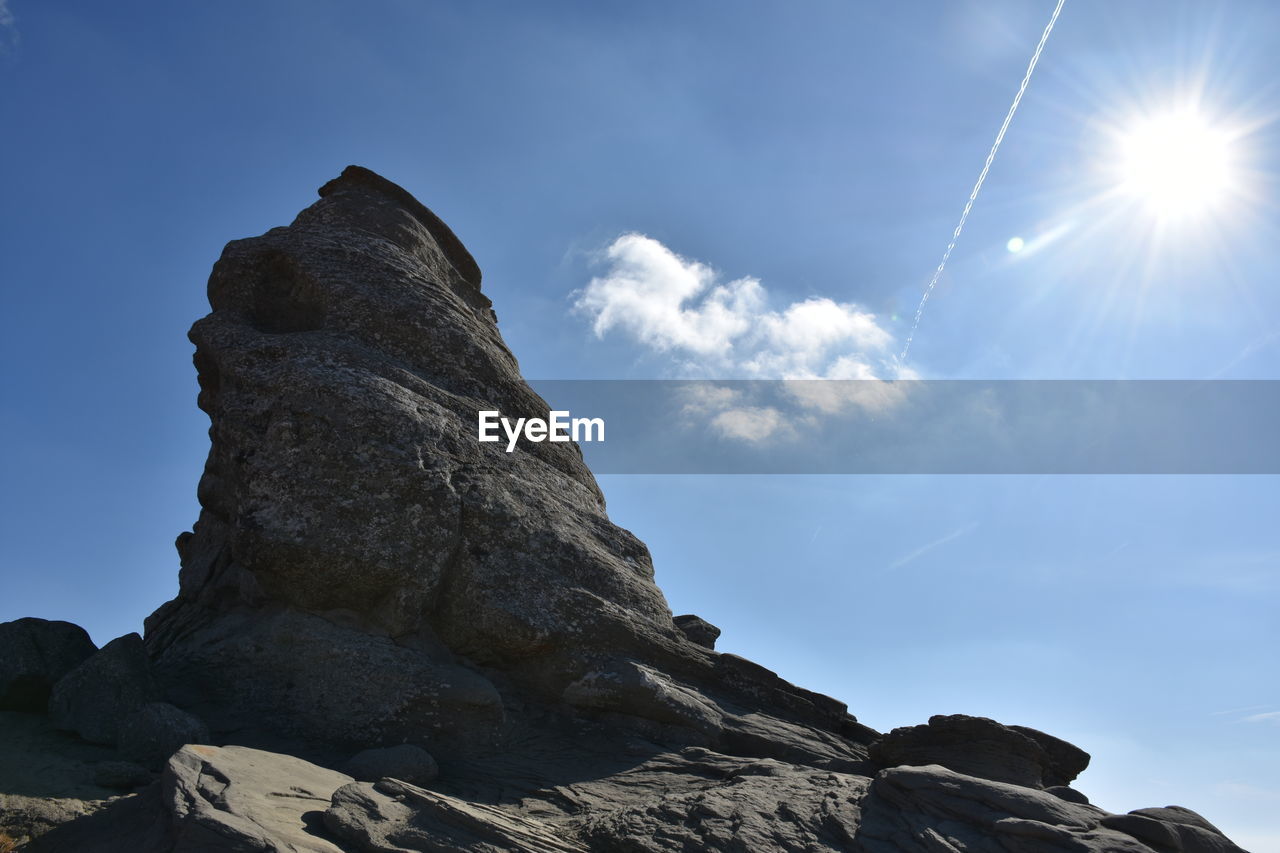 LOW ANGLE VIEW OF ROCK FORMATION ON SUNNY DAY