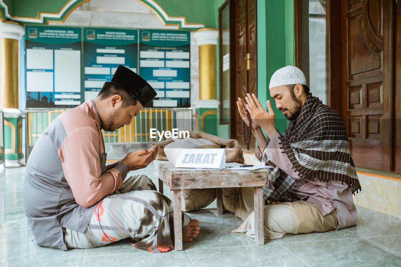 Young men praying together to allah in mosque