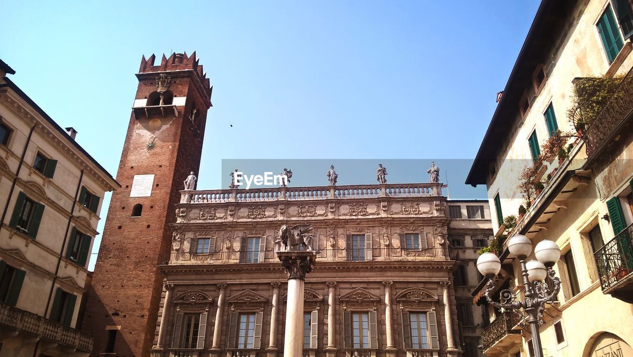 Low angle view of buildings against clear blue sky