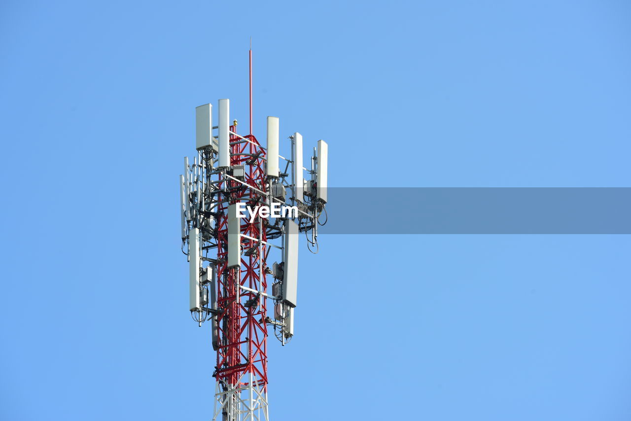 Low angle view of communications tower against clear blue sky