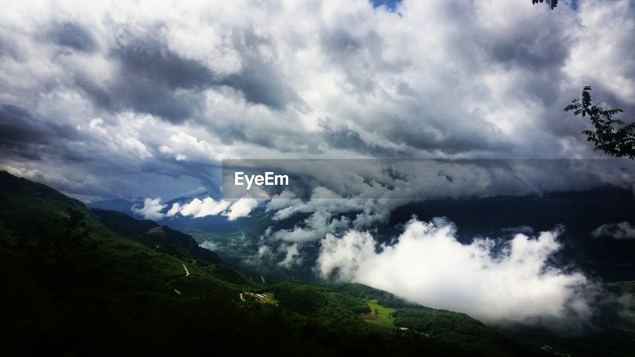 SCENIC VIEW OF MOUNTAINS AGAINST CLOUDY SKY