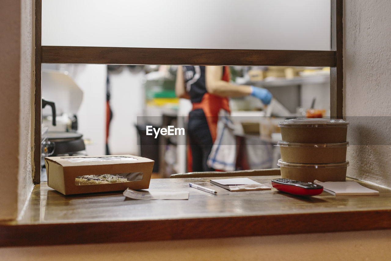 Cooks in a restaurant preparing takeaway food. the containers used are compostable.