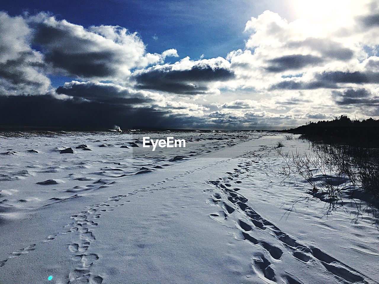 PANORAMIC VIEW OF FROZEN LAKE AGAINST SKY