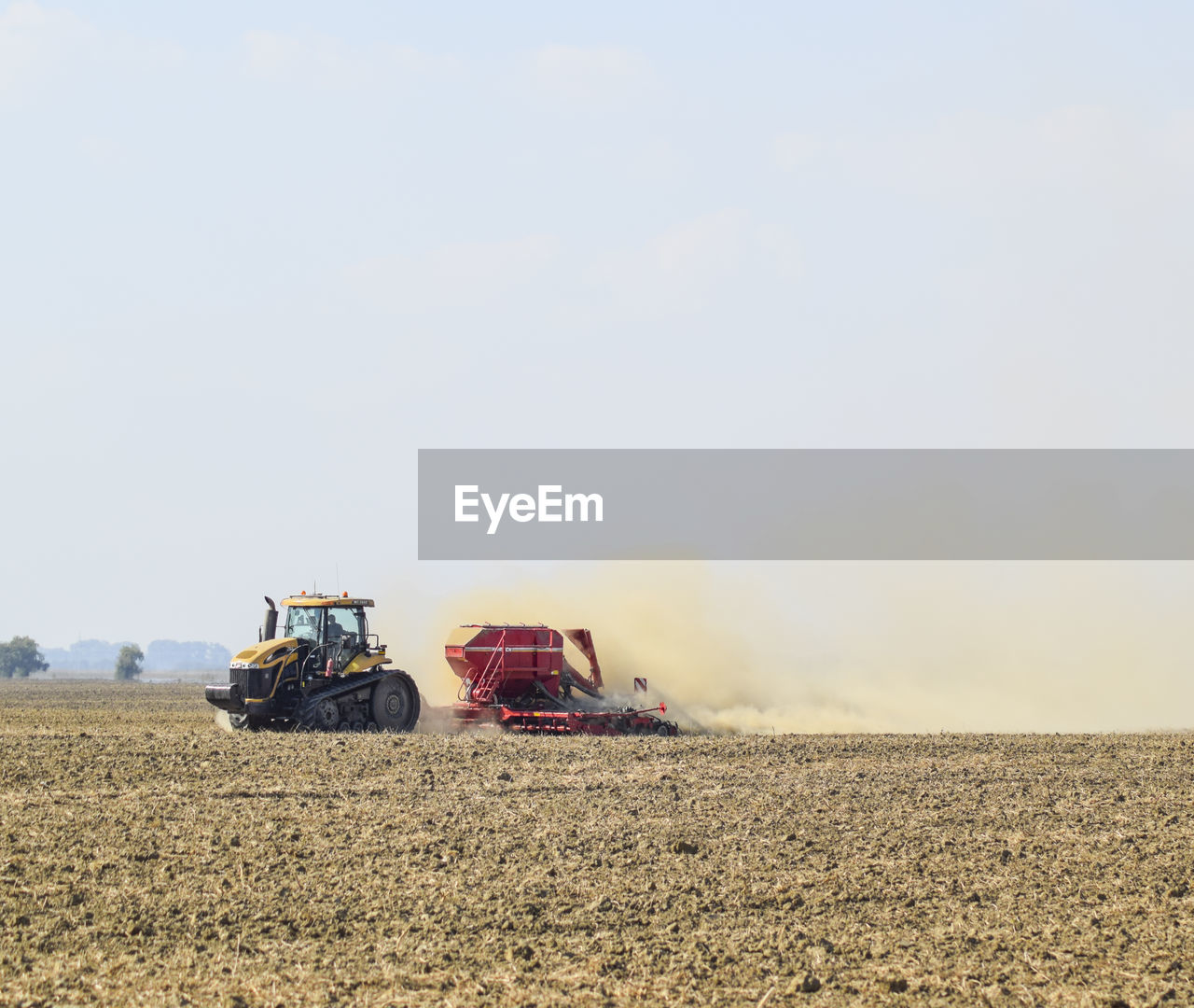 TRACTOR ON FIELD AGAINST SKY