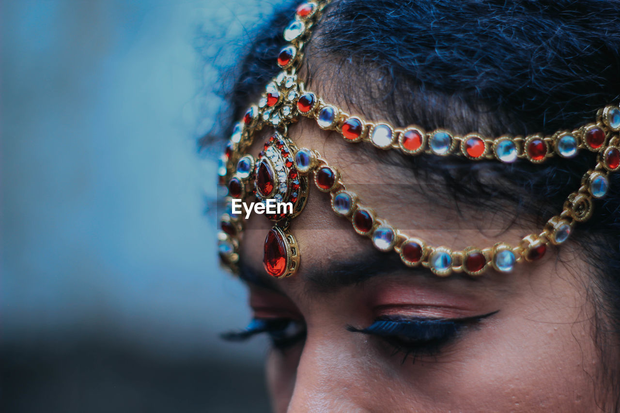 Close-up of woman wearing make-up and jewelry